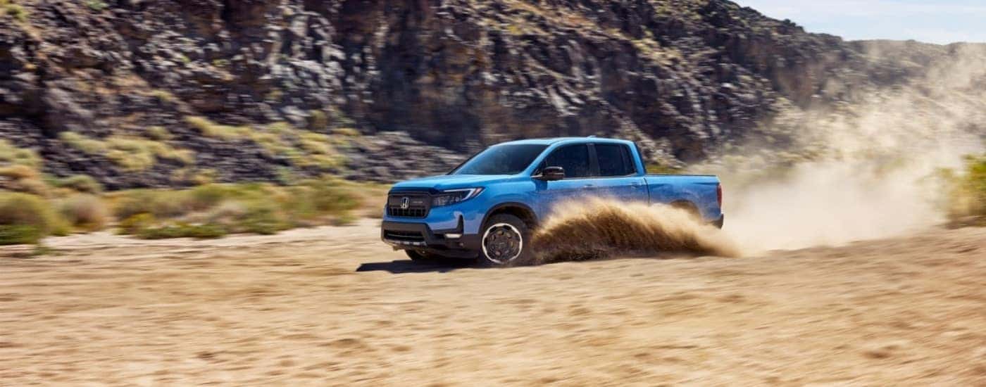 Blue 2026 Honda Ridgeline driving off-road.