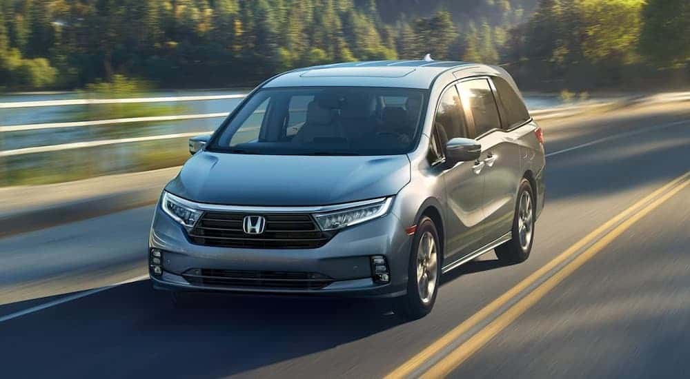Silver 2021 Honda Odyssey driving down an open road