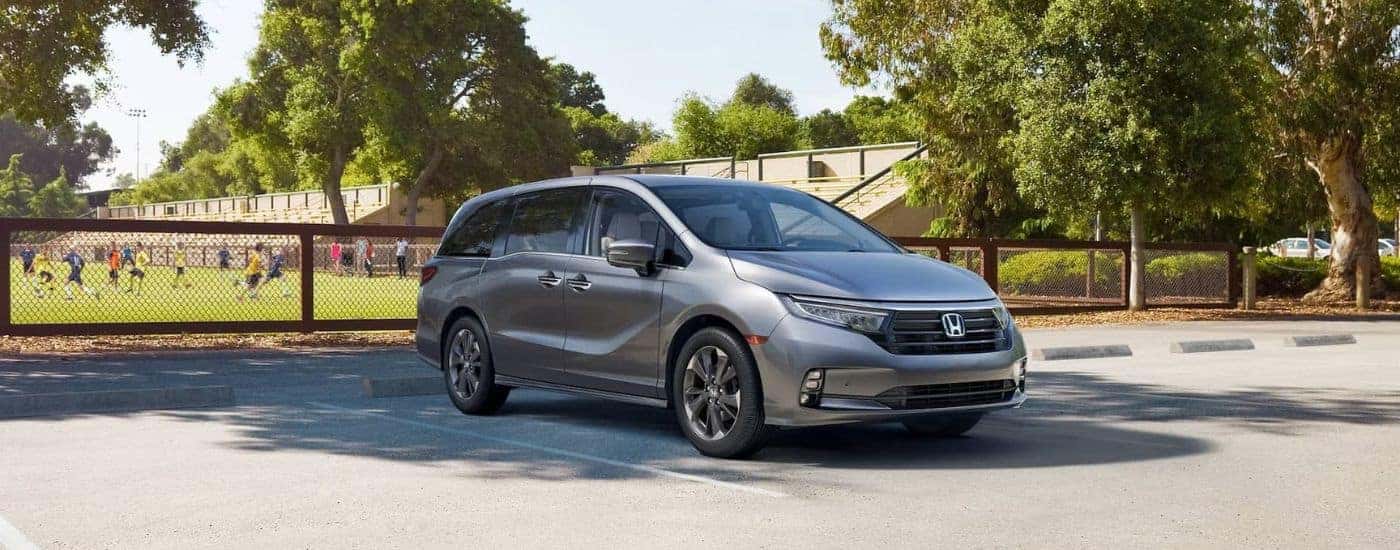 A silver 2025 Honda Odyssey parked near a soccer field