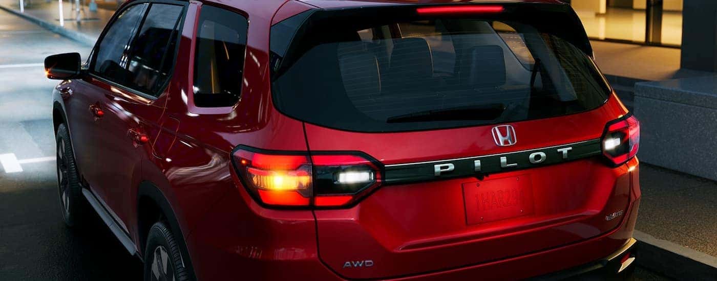 Rear taillights on a red 2026 Honda Pilot at night