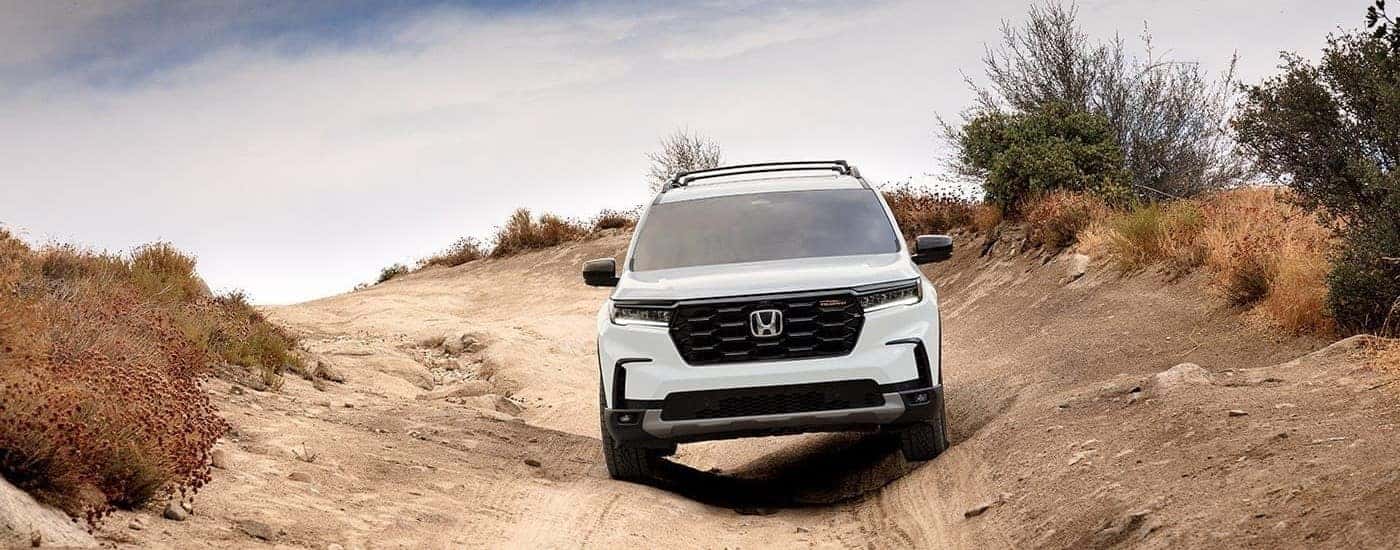 A white 2026 Honda Pilot TrailSport off-roading