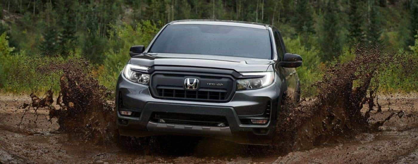 A gray 2024 Honda Ridgeline driving through mud.