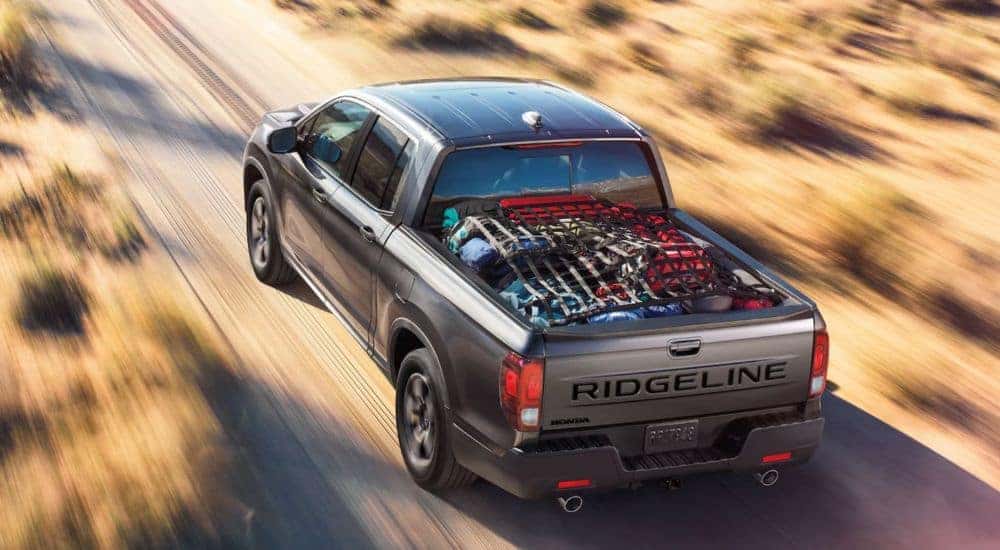 A silver 2026 Honda Ridgeline shown driving with a blurred background.