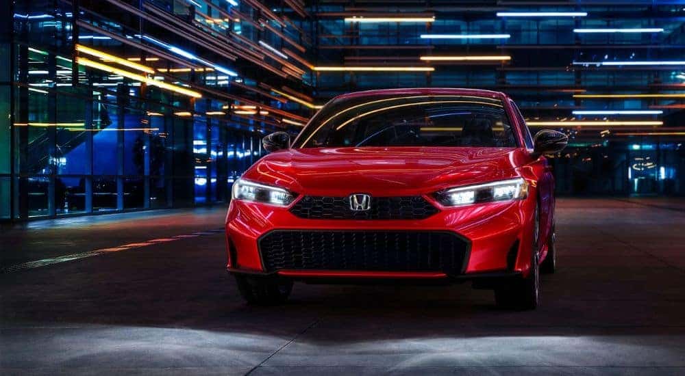 Red 2026 Honda Civic parked near a building at night.