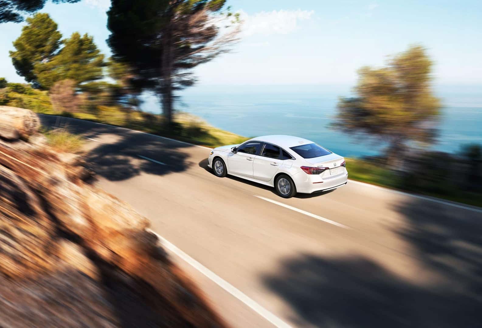 Honda Civic on a water-lined highway