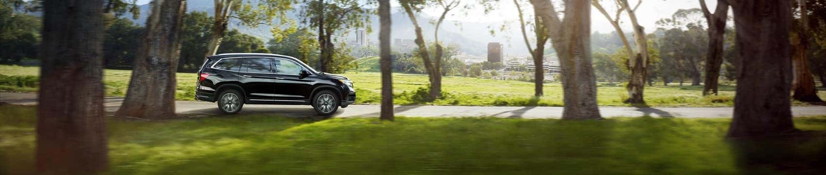 Honda Pilot on a tree-lined street