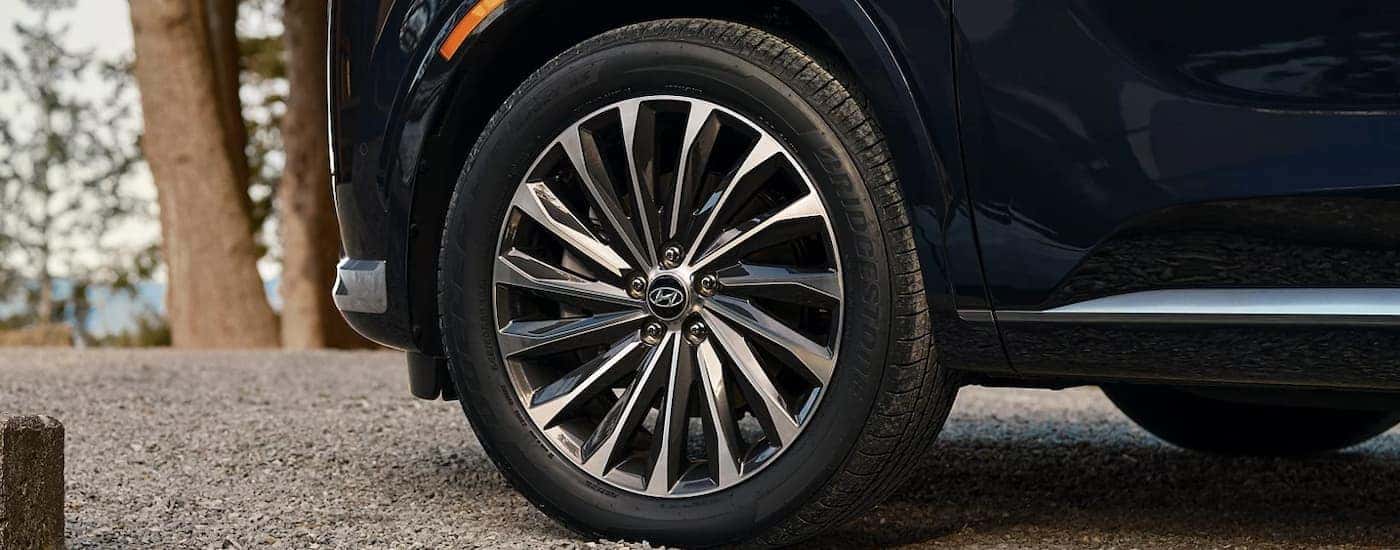 A close up of the side and wheel of a black 2025 Hyundai Palisade Calligraphy.