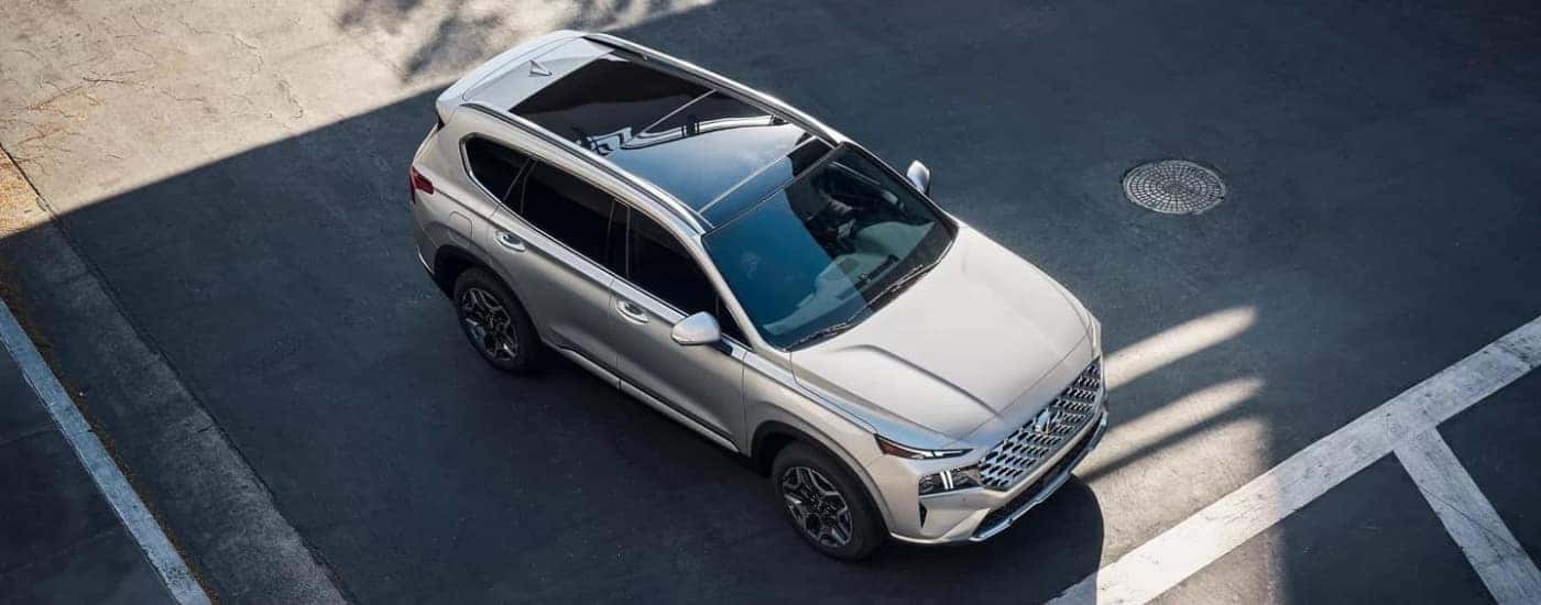 A silver 2023 Hyundai Santa Fe PHEV is shown driving to a Hyundai dealer in Clermont.