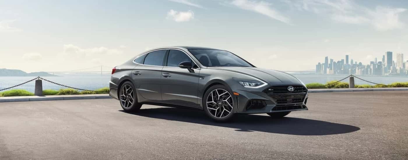 A grey 2022 Hyundai Sonata N-Line is parked near a city.
