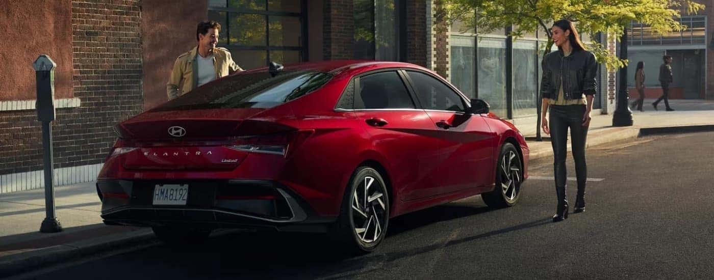 A red 2025 Hyundai Elantra is shown on a city street.