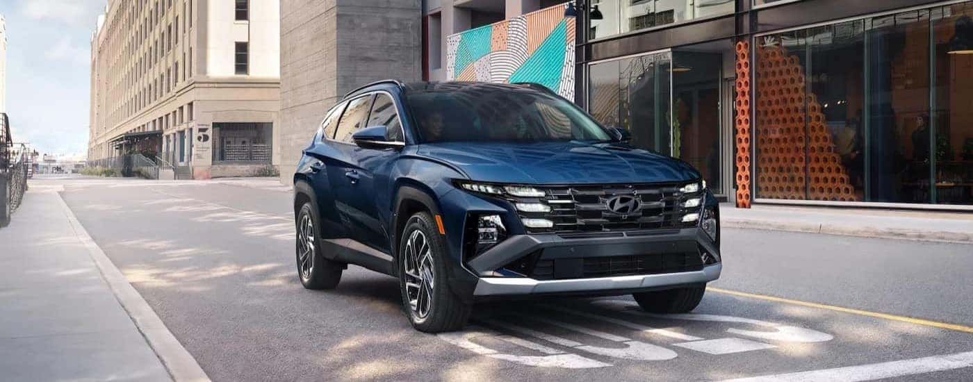 A blue 2025 Hyundai Tucson stopped at an intersection.