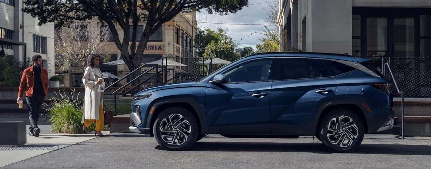 A blue 2025 Hyundai Tucson parked in a city.