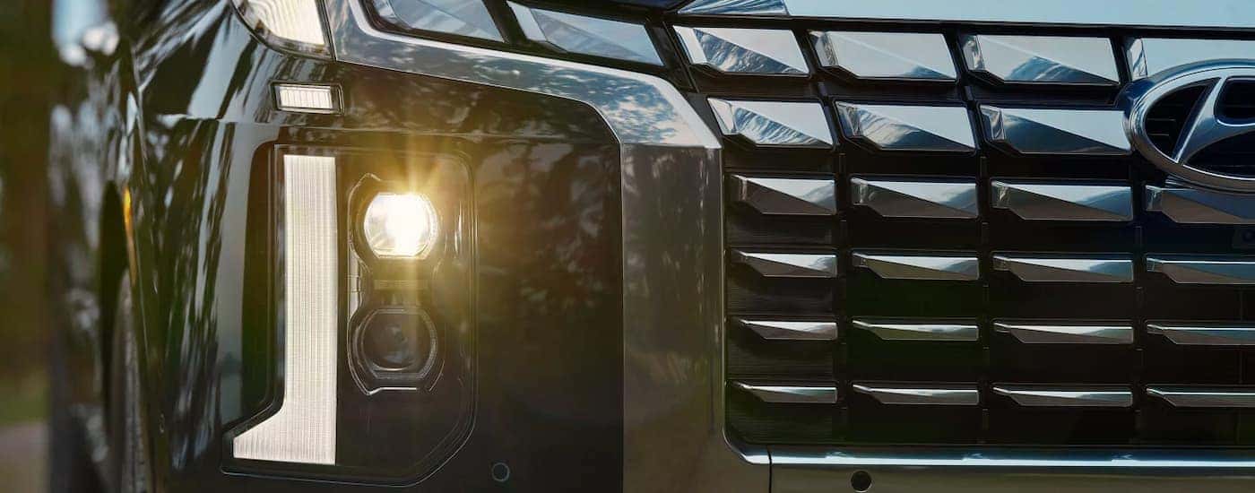 Close up of the grille and light on a blue 2025 Hyundai Palisade