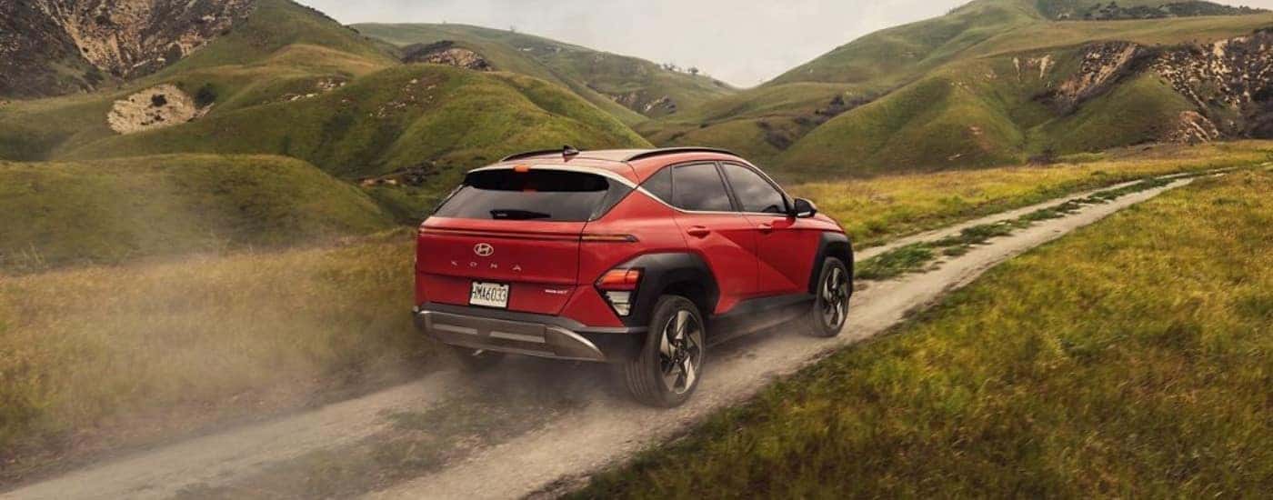 An orange 2025 Hyundai Kona from the rear at an angle.