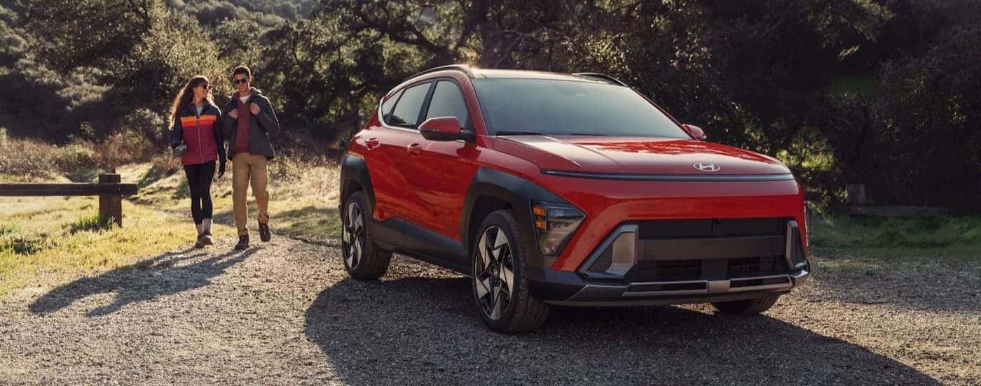 A red 2026 Hyundai Kona parked near hikers.