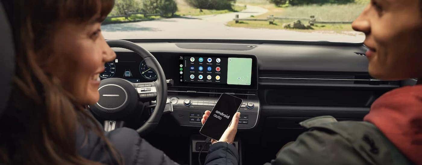 People using the tech features inside a 2026 Hyundai Kona for sale near me