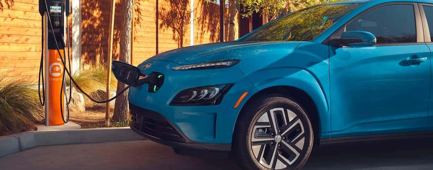 A blue 2023 Hyundai Kona charging.