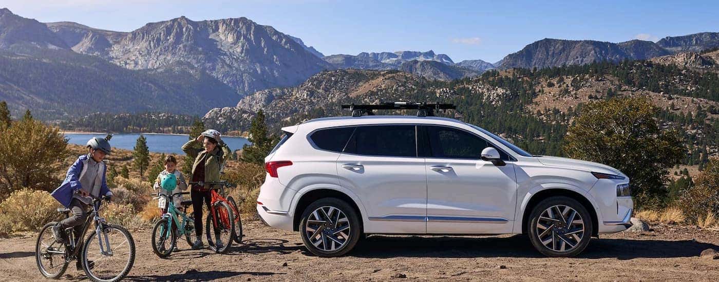A family on bikes next to their white 2023 Hyundai Santa Fe