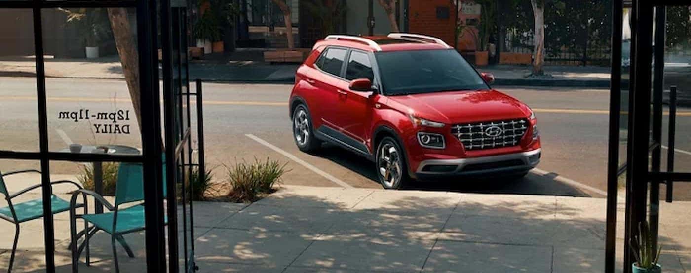 A red 2026 Hyundai Venue parked on a city street.