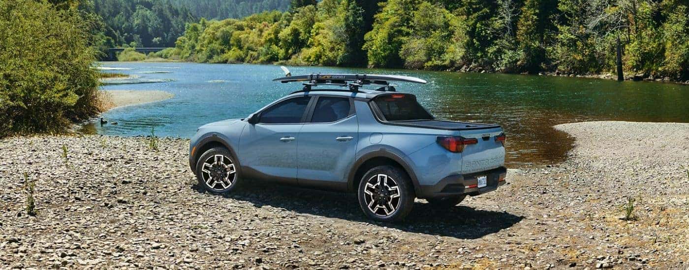 A blue 2026 Hyundai Santa Cruz Limited parked on a lake beach.