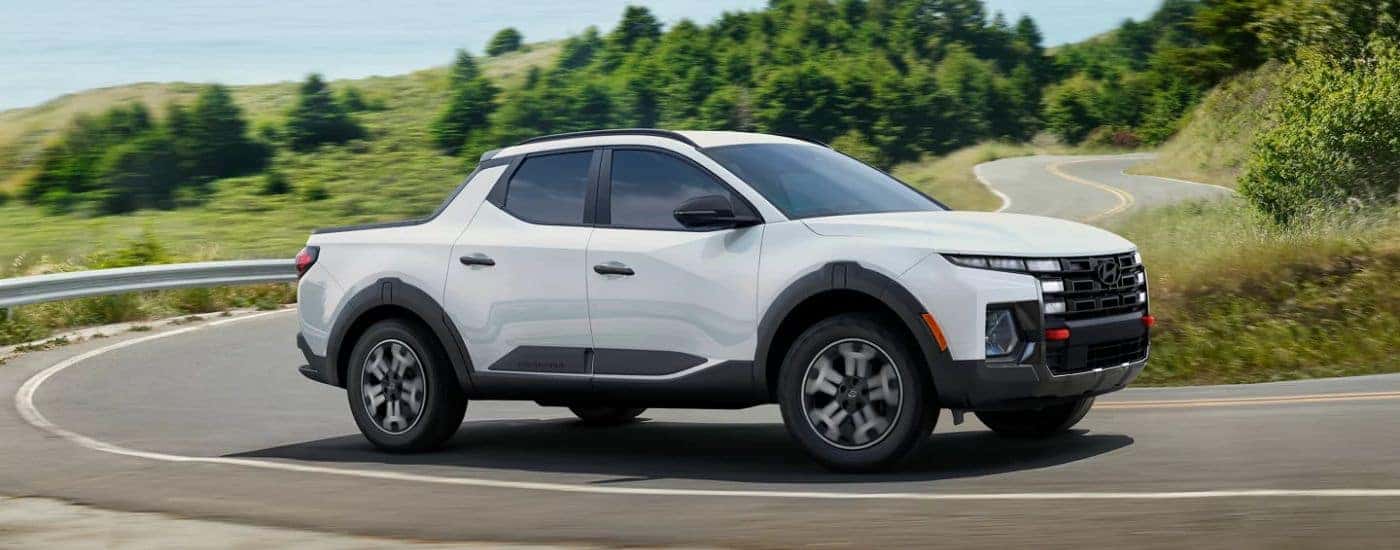 A white 2026 Hyundai Santa Cruz shown driving a corner.
