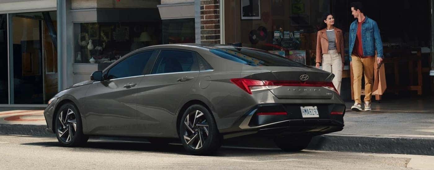 Grey 2026 Hyundai Elantra Hybrid parked near a record store