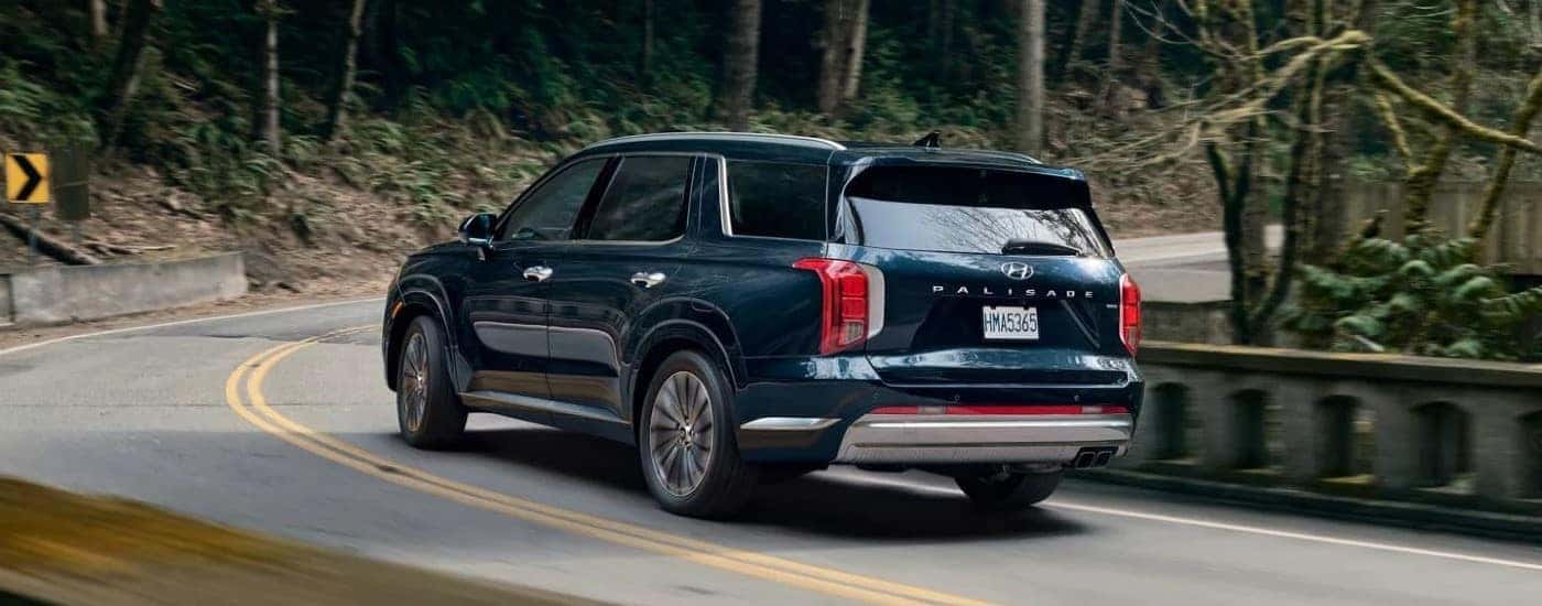 Green 2023 Hyundai Palisade rounding a corner