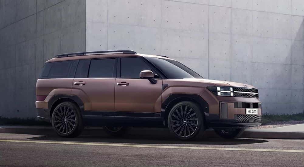 A brown 2024 Hyundai Santa Fe parked near concrete walls.