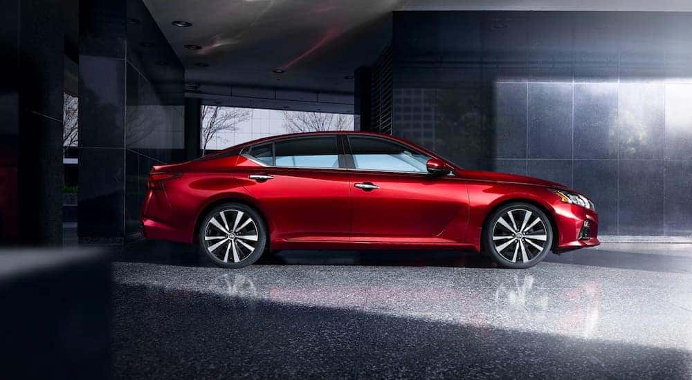 A red 2021 Nissan Altima is shown from the side parked in a marble foyer.
