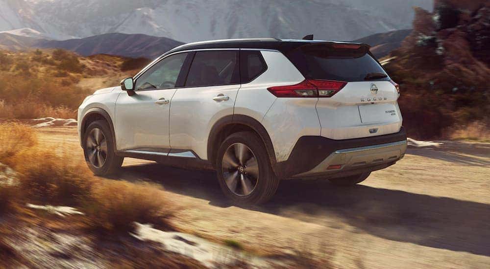 A white 2021 Nissan Rogue is off-roading in the mountains after leaving a Nissan dealer in Danville.