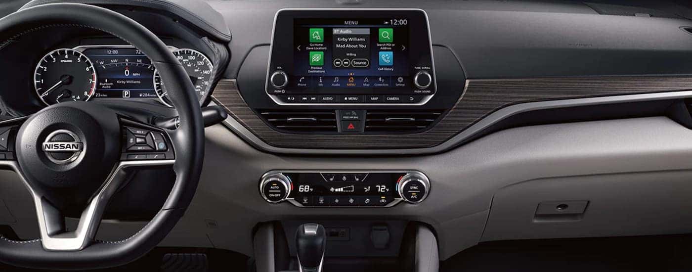 The grey interior and infotainment screen of a 2021 Nissan Altima are shown.