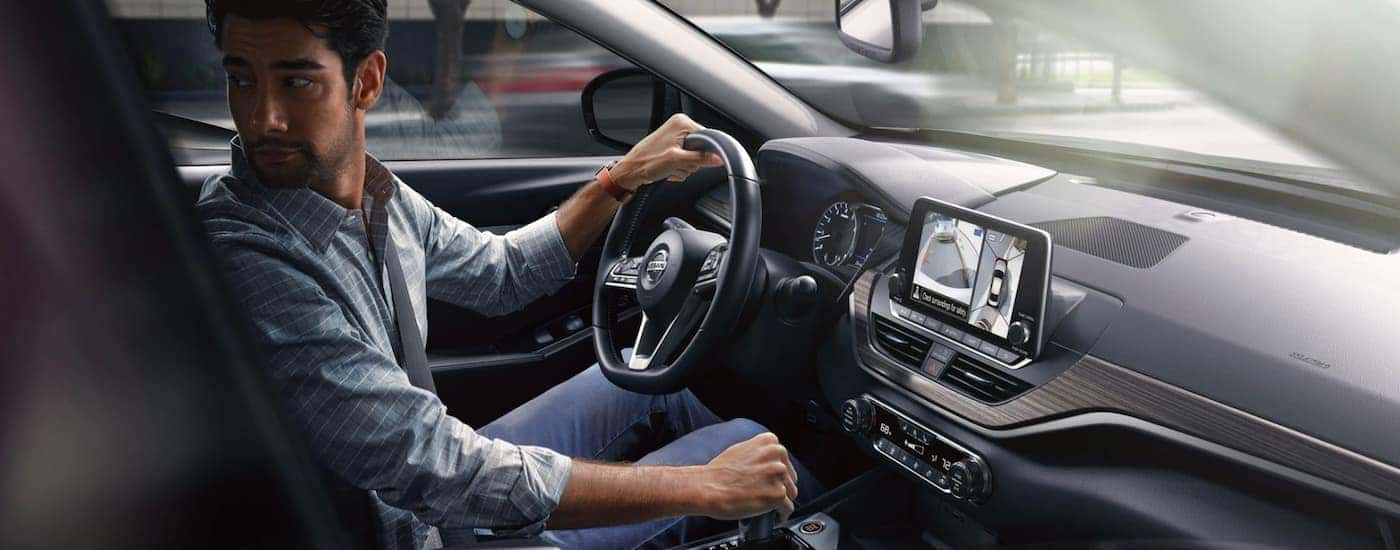 A man is shown driving a 2021 Nissan Altima.
