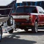 A red 2021 Nissan Titan XD is shown from the rear towing a boat.