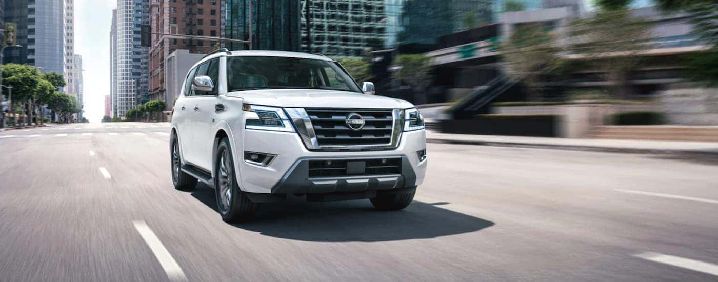 A white 2022 Nissan Armada is shown from the front driving through a city.