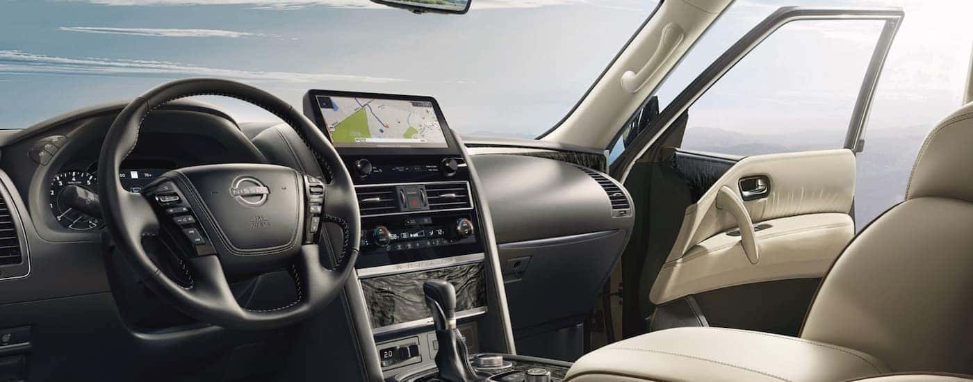 the grey interior of a 2022 Nissan Armada shows the infotainment screen and steering wheel.