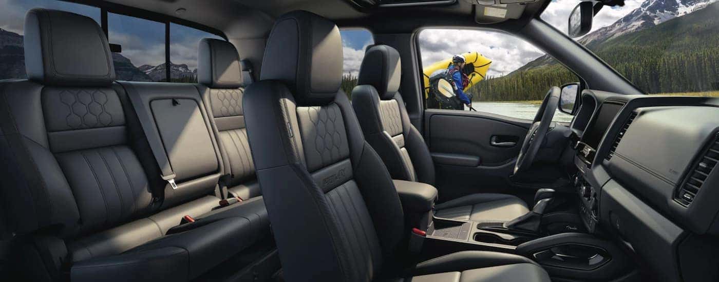 The grey interior of a 2022 Nissan Frontier shows two rows of seating.