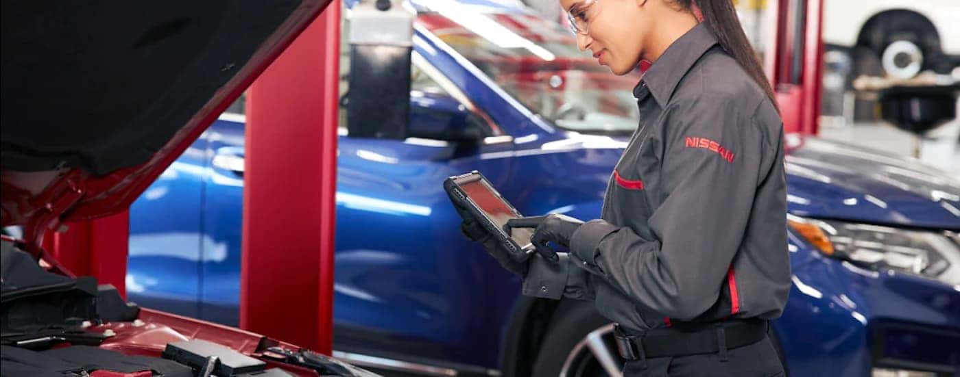 A Nissan technician is shown inspecting a vehicle.