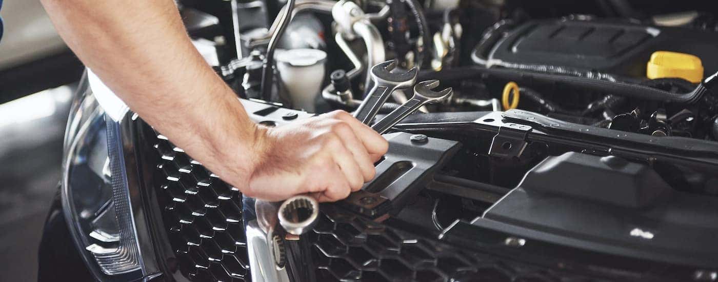 A mechanic is shown preforming a service on a car.