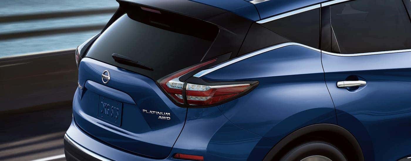 A close up of the rear of a blue 2022 Nissan Murano Platinum is shown driving on a highway.