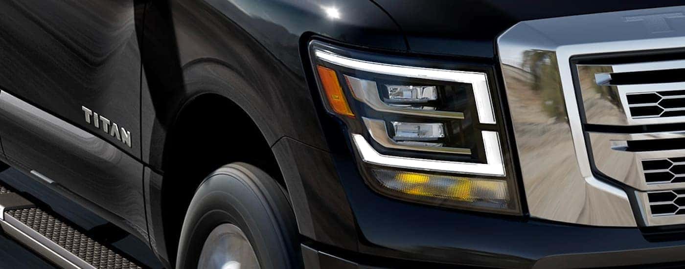 A close up shows the headlight on a black 2022 Nissan Titan after winning a 2022 Nissan Titan vs 2022 Chevy Silverado 1500 comparison.