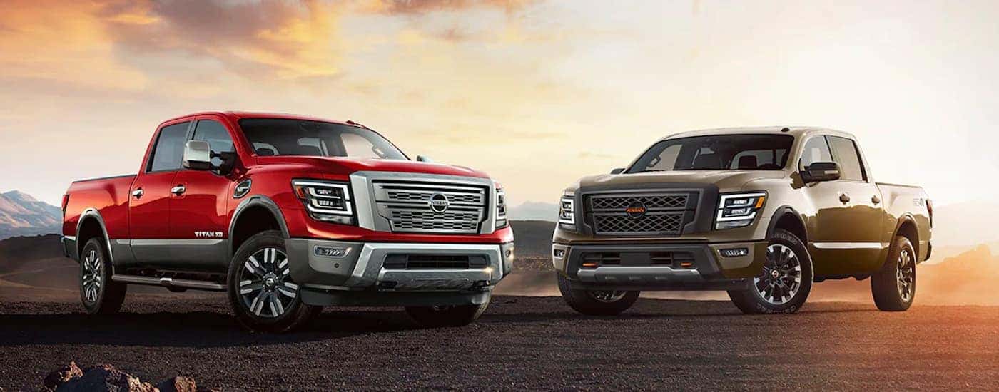 A red 2022 Nissan Titan XD and a brown Titan are shown angled toward each other.