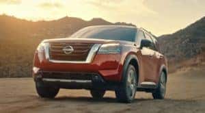 A red 2022 Nissan Pathfinder is shown driving off-road.
