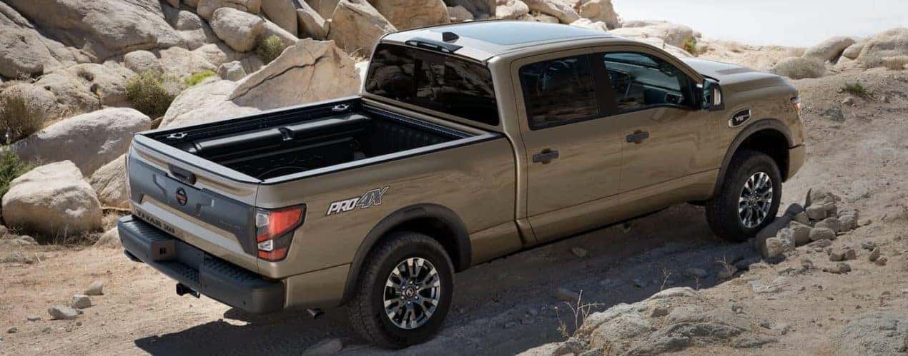 A tan 2023 Nissan Titan XD is shown off-roading in a desert.