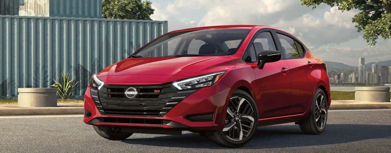 Red 2023 Nissan Versa SR parked outside of a city