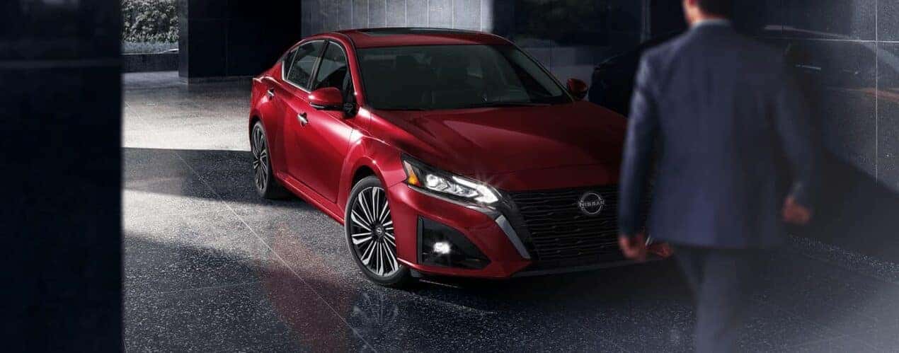 A red 2023 Nissan Altima SL is shown parked at a hotel lobby.