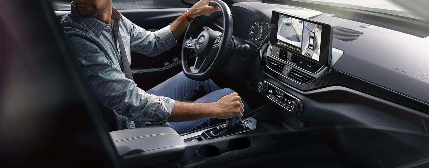 A man is shown reversing in a 2023 Nissan Altima SR during a 2023 Nissan Altima vs 2023 Honda Accord comparison.