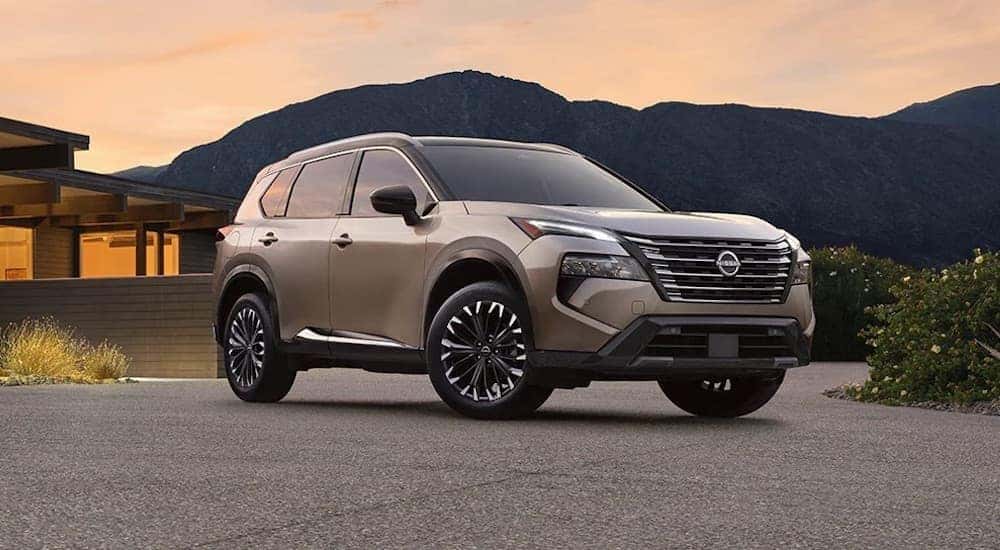 A brown 2024 Nissan Rogue is shown parked outside a building.