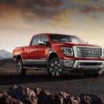 A red 2024 Nissan Titan XD is shown parked off-road.