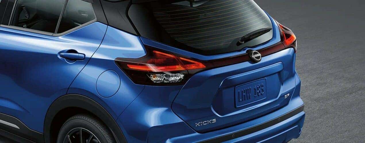 A close-up on the rear of a blue 2024 Nissan Kicks SR is shown.