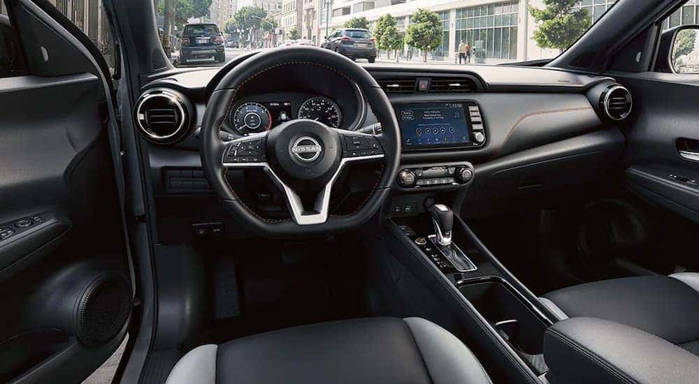 The front seats and dashboard of a 2024 Nissan Kicks SR for sale.